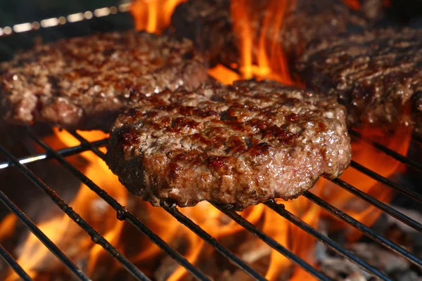 Biftek ya da domuz eti barbeküsü hamburgerleri BBC alev ızgarasında kızartılmış, yüksek açı manzaralı.