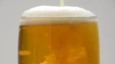 Arka plan kabarcıkları ile dökme bira kadar ve cam köpük, bantlayın kapatıp, akan üst, düşük açılı yan görünüm, ağır çekim üzerinde çalıştırın