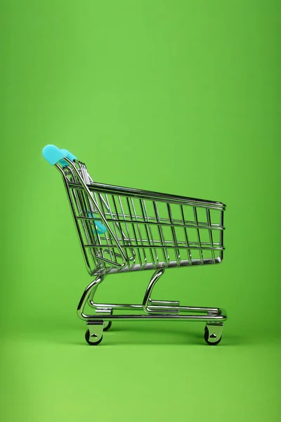 Feche Carrinho Compras Vazio Supermercado Metal Brinquedo Sobre Fundo Verde — Fotografia de Stock