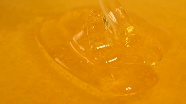 Gros plan miel d'acacia fluide épais frais coulant et coulant dans le bol, vue grand angle, ralenti 