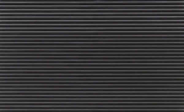 Background texture of dark grey or black color painted horizontal metal window roller shutter blinds