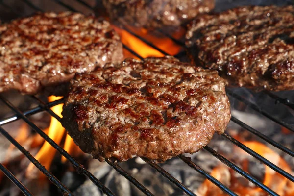 Biftek ya da domuz eti barbeküsü hamburgerleri BBC alev ızgarasında kızartılmış, yüksek açı manzaralı.