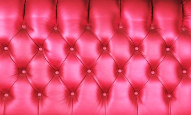 Pembe kapitonun arkaplan dokusu hakiki deri, retro Chesterfield tarzı yumuşak mobilya döşemesi derin elmas desenli ve düğmeli, kapat.