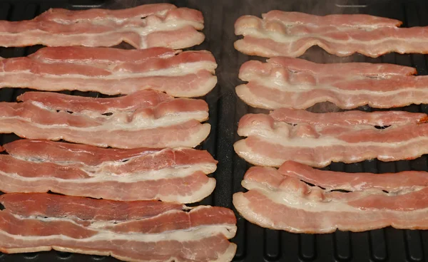 Close-up koken spek segmenten op elektrische grill — Stockfoto