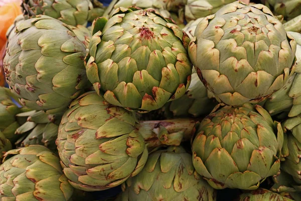 Green fresh globe artichokes on market stall — Stock Photo, Image