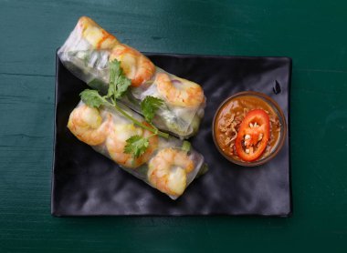 İki taze bahar rulo ile karides ve hemen üstüne masa üzerinde yükseltilmiş üstten görünüm chili sos plaka üzerinde daldırma kısmını kapatın