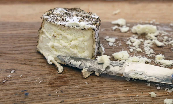 关闭一个切碎新鲜的法国工匠美味山羊奶酪与香草香料和刀在木制切菜板上 高角度的观点 — 图库照片