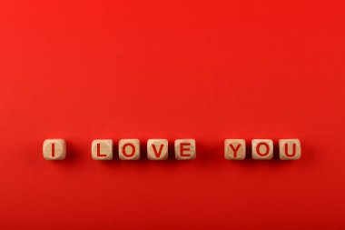Üzerinde I Love You yazıları olan tahta tabelalar kırmızı arkaplan ve kopyalama alanı, yüksek üst görünüm, doğrudan üst görünüm
