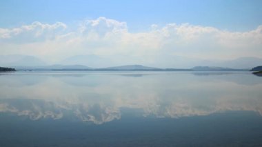 Doğal cennet ve huzurlu dağ gölü waterfront mavi bulutlu gökyüzü yansıması animasyonlu cinemagraph
