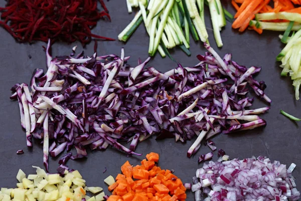 Produtos hortícolas cortados em fatias variadas na placa de cozinhar — Fotografia de Stock