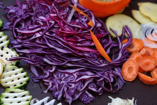 Produtos hortícolas cortados em fatias variadas na placa de cozinhar — Fotografia de Stock