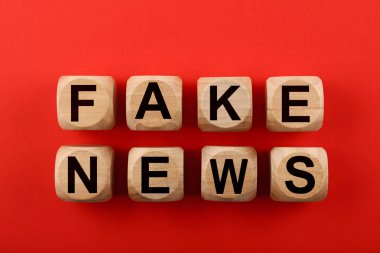 Kırmızı üzerine sahte haber içeren tahta küpler.