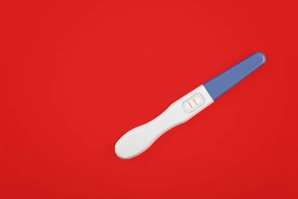 Close up positive pregnancy test over red — Stock Photo, Image