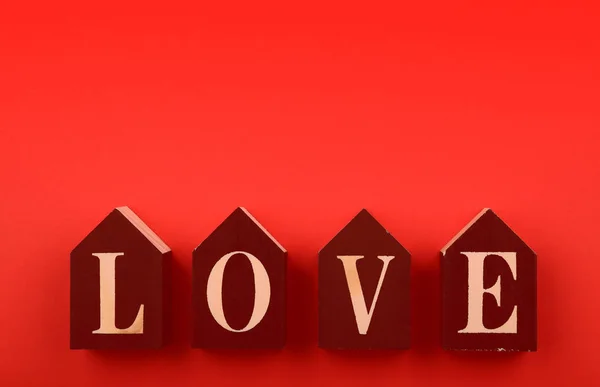 Cubos de madera con palabra LOVE sobre fondo rojo — Foto de Stock