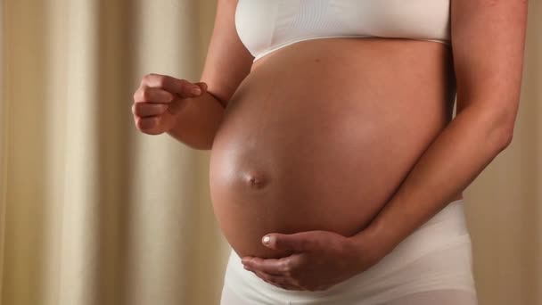 Schwangere berührt ihren Bauch mit Händen — Stockvideo