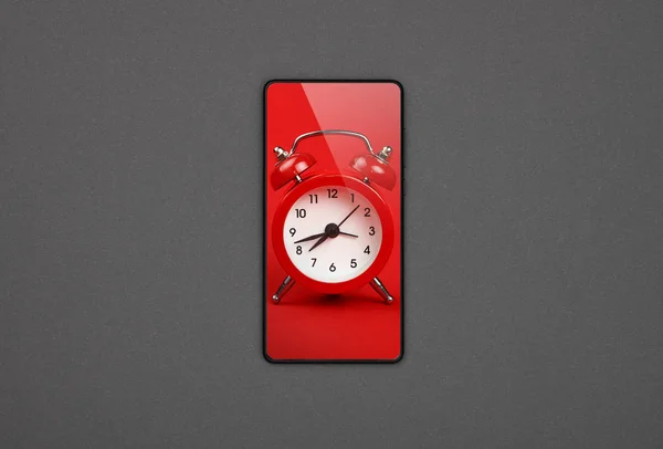 Smartphone s červeným budíku na obrazovce přes šedou — Stock fotografie