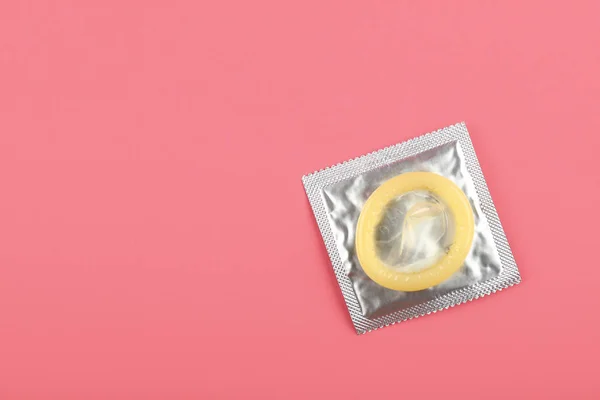 Zamknij jeden pakiet prezerwatywy na różowym tle — Zdjęcie stockowe