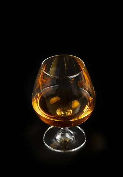 Glas Cognac oder Brandy isoliert auf schwarz — Stockfoto