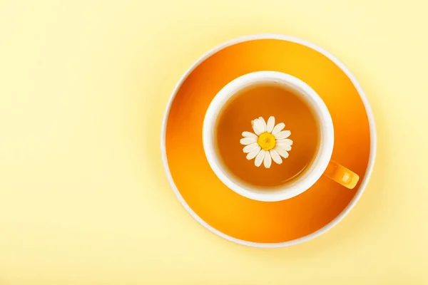 Желтая чашка травяного чая с ромашкой — стоковое фото