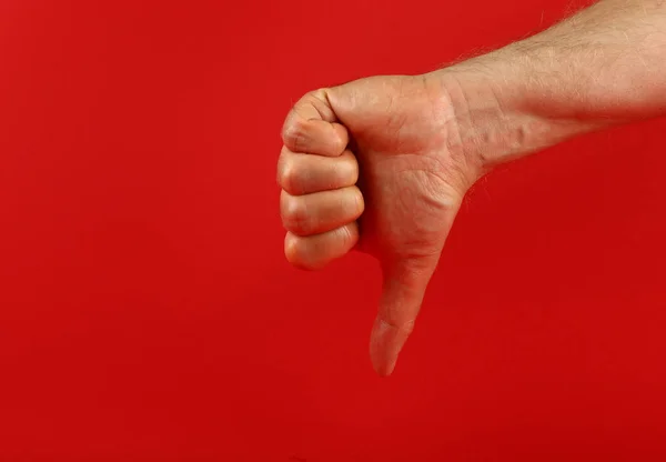 Férfi kéz utálatos gesztussal a piros felett — Stock Fotó