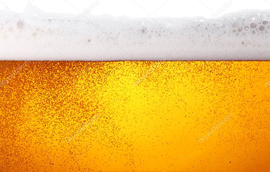 Close up background texture of lager beer with bubbles and froth in glass, low angle side view