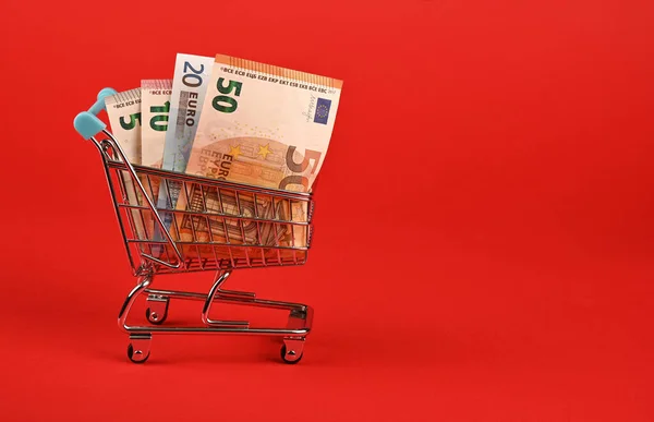 Close Van Verschillende Europapierbankbiljetten Klein Winkelwagentje Rode Achtergrond Lage Hoek — Stockfoto