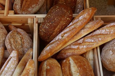 Bir kaç çeşit taze buğday ekmeğini ve ekmeği pastanenin perakende vitrininde ahşap kutuda, yüksek açılı manzarada kapat.