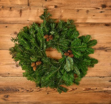 Taze yeşil ladin dallarının Noel çelenklerini kapayın. Ahşap duvarlı, ön manzaralı.