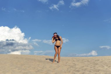 Bir esmer sıcak kum üzerinde yürümek