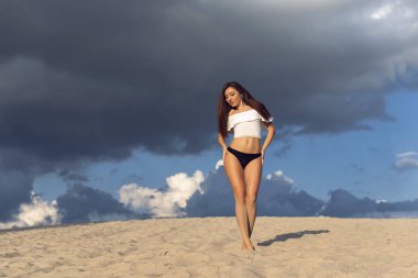 Bir esmer sıcak kum üzerinde yürümek