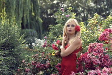 Güller ile bahçede Olgun sarışın