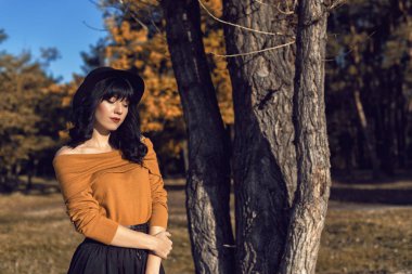 Sonbahar parkında bir esmerle yürü.