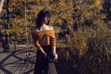 Sonbahar parkında bir esmerle yürü.