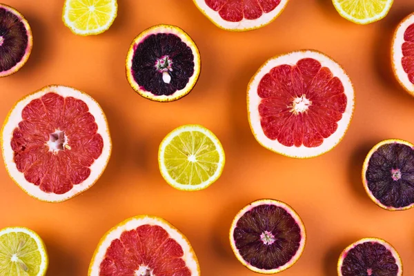Citrus fruits flat lay pattern in sunlight on orange background. Banner design template, wallpaper