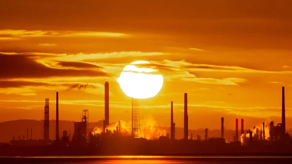 Küresel Isınma İklim Değişikliği Conceptepic stanlow Petrol Rafinerisi ve Mersey Haliç Wirral üzerinde enerji santralinde gündoğumu. Sera gazı emisyonları ve kirlilik bir endüstriyel şafakta gezegen ısı. 