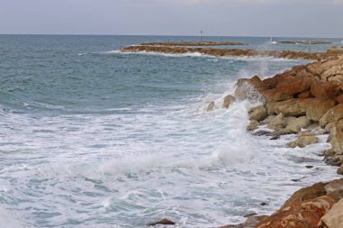 Deniz kayaların kıyısıdır.