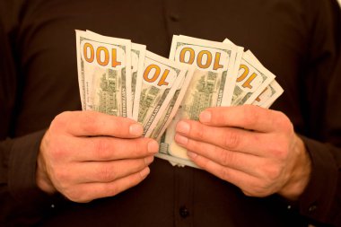 Bir adam dolar elinde tutar.