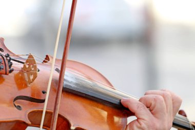 Adam sokakta keman çalıyor.