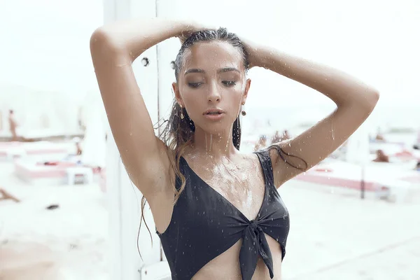 照片中的一个女孩在黑色比基尼站在淋浴 美丽的脸 炎热的夏天 阳光明媚 — 图库照片
