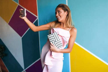  Bir selfie telefon, iş, eğlenceli, defter, pembe elbise, saç stili, makyaj, çalışma, dinlenme, internet, iletişim, Güzellik, moda, gülümseyen, üzerinde neşeli alarak aktif genç erkek