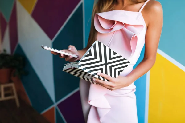 Jovencita Vestido Rosa Grabando Teléfono Sosteniendo Cuaderno Pie Cerca Pared — Foto de Stock