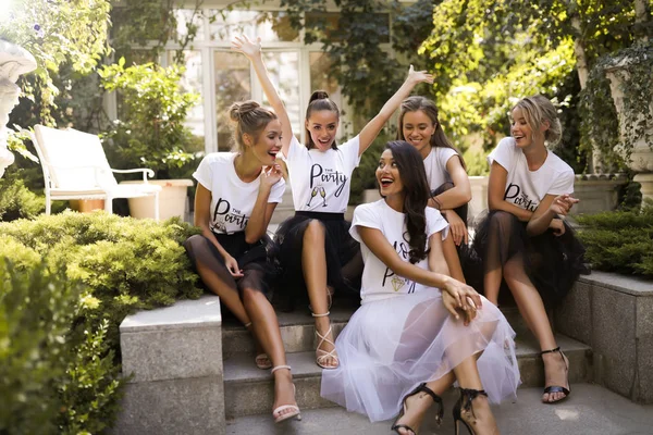 Group of young active girls in the same clothes posing to make a picture, white t-shirt, black skirt, having fun, smiling, cheerful, modern, outdoor, make up, party