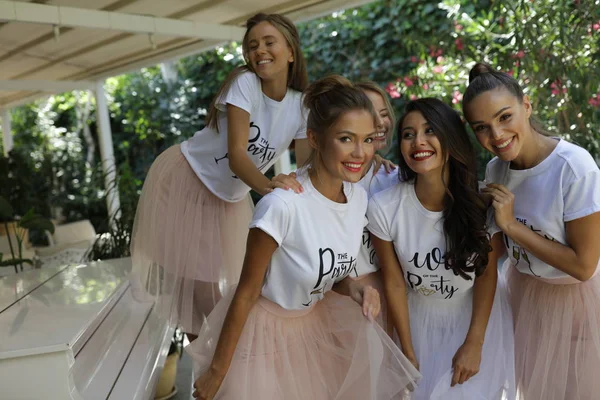 活跃年轻妇女在淡粉色裙子和白色 T恤与标题站立附近钢琴 — 图库照片