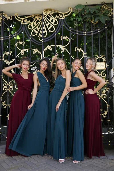 五伴娘在令人惊叹的红色和绿色礼服摆在门口 有乐趣 — 图库照片