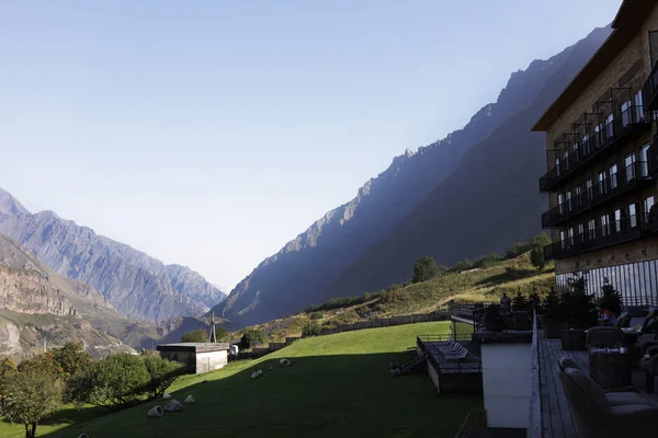 Panoramic view from the hotel in the mountains, calm and peace, beautiful nature, green grass, field, sun shine, rest, joy, travel, rocks, trees, birds singing, blue sky