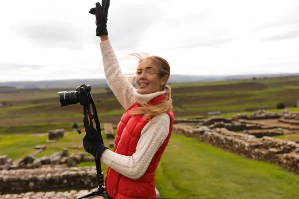 Energická Mladá Žena Stojící Vedle Fotoaparátu Zvedá Ruku Zatažené Podzimní — Stock fotografie