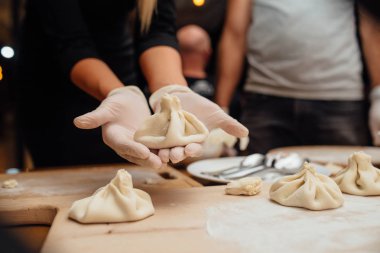 Kadın pişirme Hıngel, ulusal Gürcü mutfağı bir master class yürütmektedir. Et bir hamur olarak farklı baharatlar olan torba sarılı olarak. Eller bir bitmiş. 