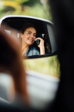 Diğer kişilere radyoda konuşuyor Arabada neşeli genç bayan. Georgia etrafında arkadaş ile seyahat. Araba aynaya güzel sarışın.