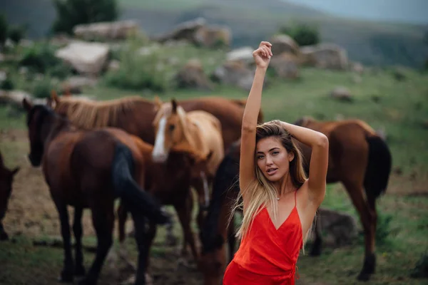 Kobieta Czerwonej Sukience Dzikie Konie Tła Wypas Polu Obok Młoda — Zdjęcie stockowe