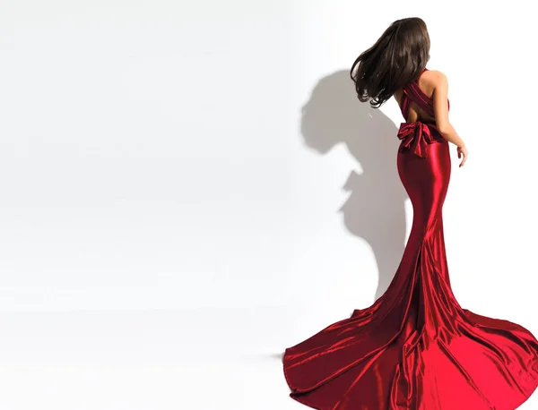 豪华红色晚地图集礼服上的黑发模型 在后面鞠躬 长裙下摆 挥动的头发 完美的身体 — 图库照片